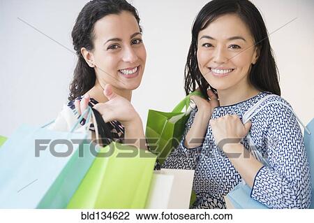 Smiling women shopping together View Large Photo Image Stock Image - Smiling women shopping together. Fotosearch