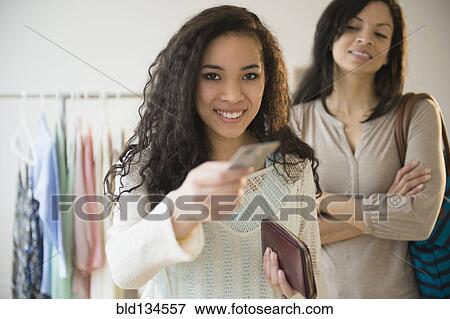Stock Photo - Teenage girl paying with credit card in store. Fotosearch