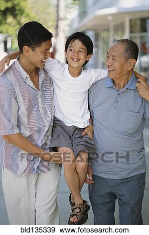Three generations of men walking on city street View Large Photo Image Stock Photo - Three generations of men walking on city street. Fotosearch