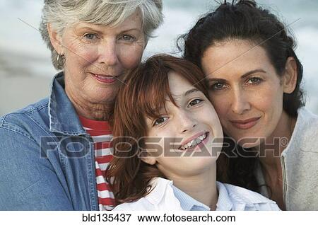 Stock Photo - Three generations of women smiling on beach. Fotosearch