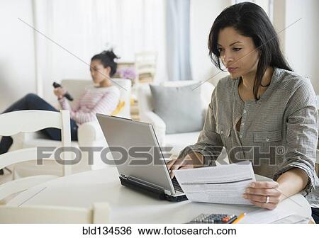 Stock Photograph - Woman paying bills online. Fotosearch