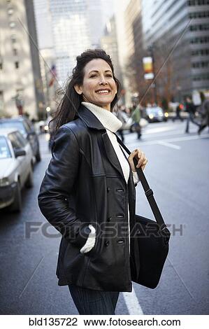 Woman smiling on city street View Large Photo Image Stock Image - Woman smiling on city street. Fotosearch