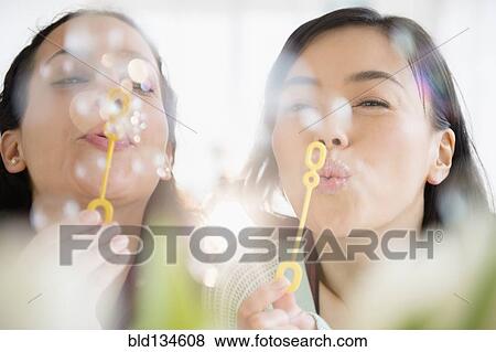 Women blowing bubbles together View Large Photo Image Stock Photo - Women blowing bubbles together. Fotosearch