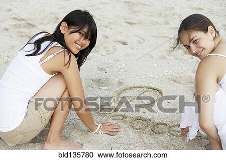 Women drawing 'peace' in sand on beach View Large Photo Image Stock Image - Women drawing 'peace' in sand on beach. Fotosearch