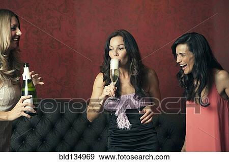 Stock Photo - Women drinking champagne in nightclub. Fotosearch