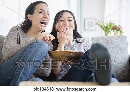 Women laughing on sofa together View Large Photo Image Stock Photo - Women laughing on sofa together. Fotosearch