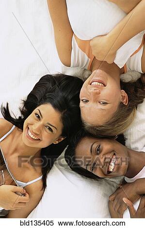Women relaxing together on bed View Large Photo Image Stock Photography - Women relaxing together on bed. Fotosearch