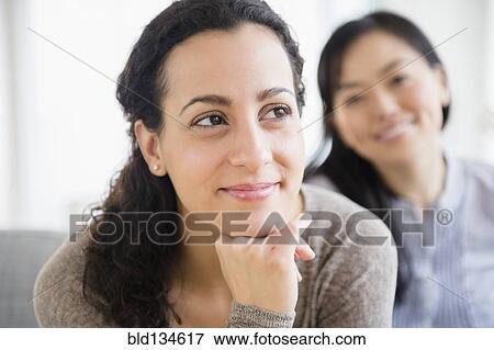 Women sitting together on sofa View Large Photo Image Stock Photo - Women sitting together on sofa. Fotosearch