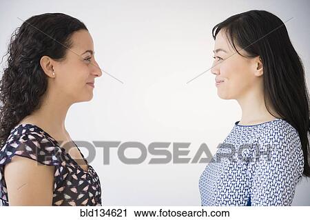 Women smiling at each other View Large Photo Image Stock Image - Women smiling at each other. Fotosearch