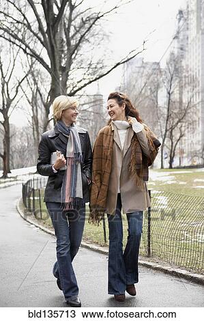 Women walking together in urban park View Large Photo Image Stock Image - Women walking together in urban park. Fotosearch