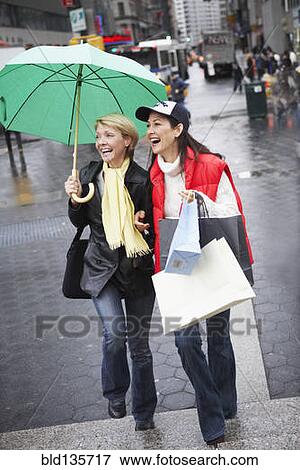 Women walking together on city street View Large Photo Image Stock Photo - Women walking together on city street. Fotosearch