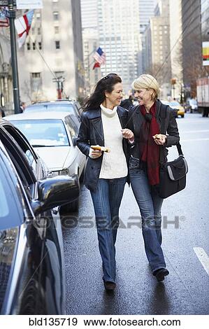 Women walking together on city street View Large Photo Image Stock Photo - Women walking together on city street. Fotosearch