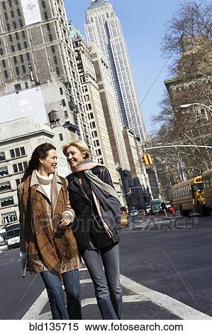 Women walking together on city street View Large Photo Image Stock Photography - Women walking together on city street. Fotosearch