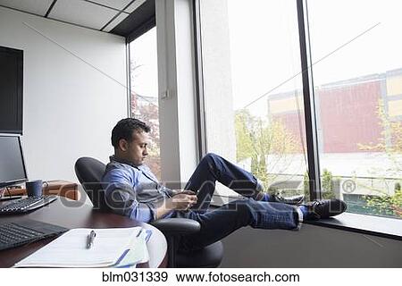 Stock Photo - Asian businessman relaxing in office. Fotosearch