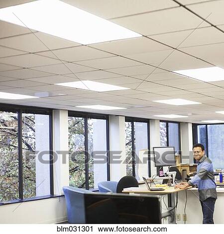 Stock Image - Asian businessman smiling in office. Fotosearch