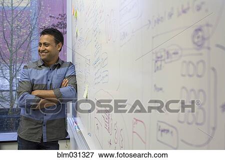 Asian businessman standing at whiteboard View Large Photo Image Stock Photo - Asian businessman standing at whiteboard. Fotosearch