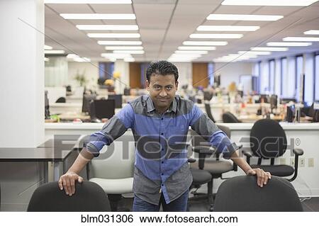 Stock Photograph - Asian businessman standing in office. Fotosearch