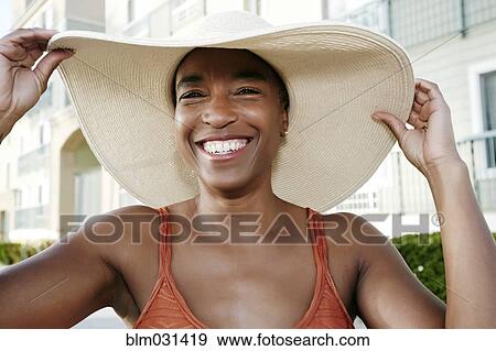 Stock Photo - Black woman wearing sun hat outdoors. Fotosearch