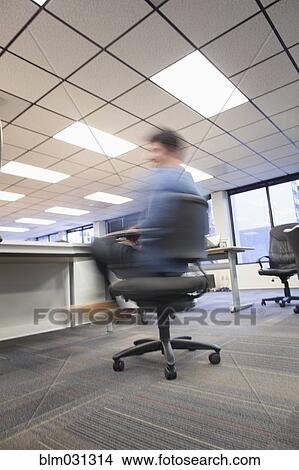 Blurred View Of Caucasian Businessman Spinning In Office Chair Businessman Spinning In Office Chair