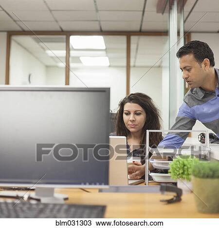 Stock Image - Business people working together in office. Fotosearch