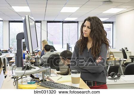 Stock Image - Businesswoman working at desk in office. Fotosearch