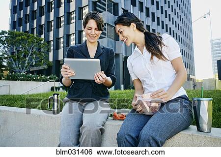 Businesswomen using tablet computer in city View Large Photo Image Stock Photograph - Businesswomen using tablet computer in city. Fotosearch