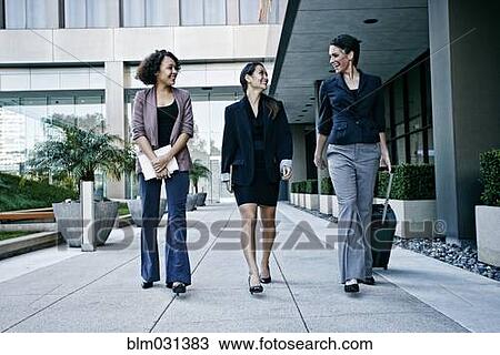Stock Image - Businesswomen walking together outdoors. Fotosearch