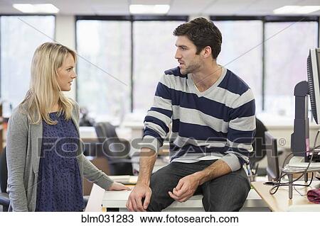 Stock Image - Caucasian business people talking in office. Fotosearch