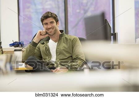 Caucasian businessman smiling at desk in office View Large Photo Image Picture - Caucasian businessman smiling at desk in office. Fotosearch