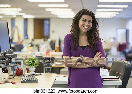 Stock Photo - Caucasian businesswoman smiling at desk. Fotosearch