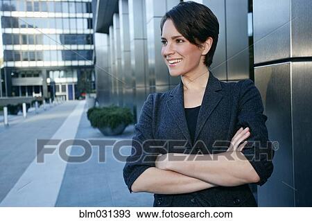 Stock Image - Caucasian businesswoman standing in city. Fotosearch