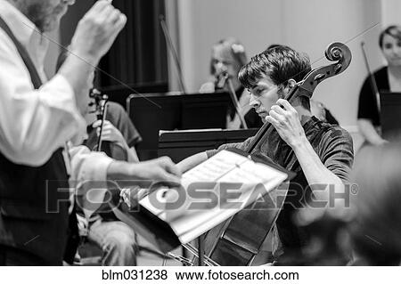Stock Photo - Caucasian student playing cello in college orchestra. Fotosearch