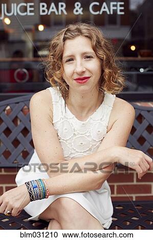 Caucasian woman sitting outside coffee shop on city street View Large Photo Image Stock Image - Caucasian woman sitting outside coffee shop on city street. Fotosearch