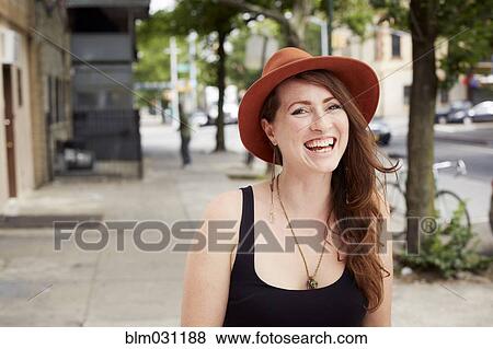 Stock Photo - Caucasian woman smiling on city street. Fotosearch