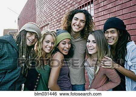 Stock Photograph - Friends smiling together on city street. Fotosearch