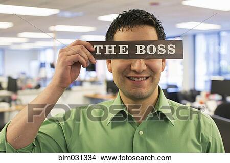 Hispanic businessman holding 'The Boss' sign over face View Large Photo Image Picture - Hispanic businessman holding 'The Boss' sign over face. Fotosearch