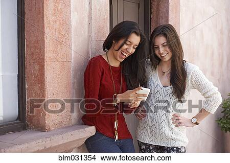 Picture - Hispanic women using cell phone. Fotosearch