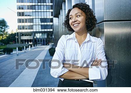 Picture - Mixed race businesswoman standing in city. Fotosearch