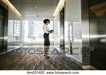 Mixed race businesswoman using tablet computer in lobby View Large Photo Image Stock Image - Mixed race businesswoman using tablet computer in lobby. Fotosearch