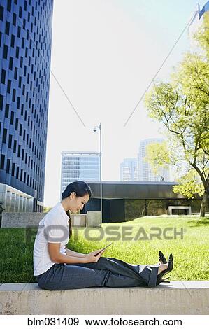 Mixed race businesswoman using tablet computer in city View Large Photo Image Stock Photo - Mixed race businesswoman using tablet computer in city. Fotosearch