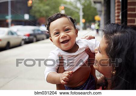 Mother playing with toddler son on city street View Large Photo Image Picture - Mother playing with toddler son on city street. Fotosearch