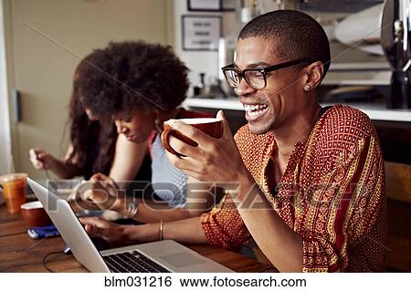 Stock Photograph - People using technology in coffee shop. Fotosearch