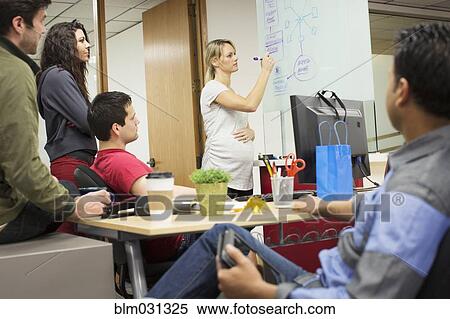Pregnant businesswoman giving presentation to colleagues in office View Large Photo Image Stock Photography - Pregnant businesswoman giving presentation to colleagues in office. Fotosearch