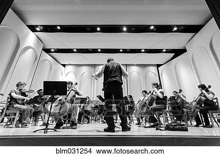 Picture - Professor conducting college orchestra. Fotosearch
