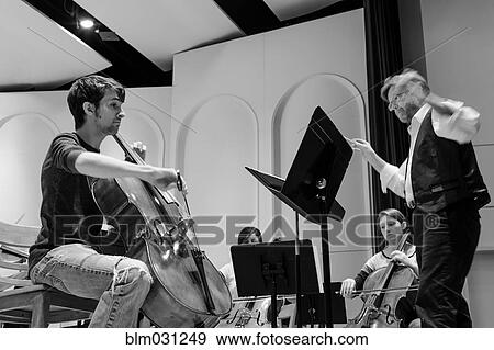 Stock Photo - Professor conducting college orchestra. Fotosearch