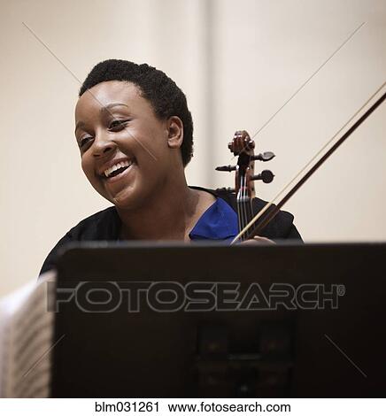 Stock Image - Student playing violin at music stand. Fotosearch
