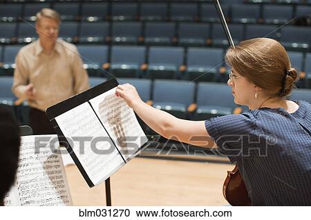 Stock Image - Student reading sheet music on stage. Fotosearch