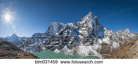 Stock Photo - Sun rising over snowy mountains in rural landscape, Tengboche, Khumbu, Nepal. Fotosearch