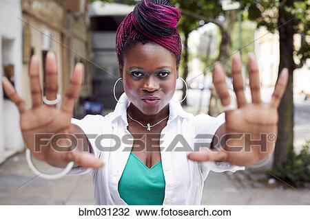 Woman holding out hands on city street View Large Photo Image Stock Image - Woman holding out hands on city street. Fotosearch