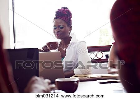 Picture - Woman using laptop in cafe. Fotosearch